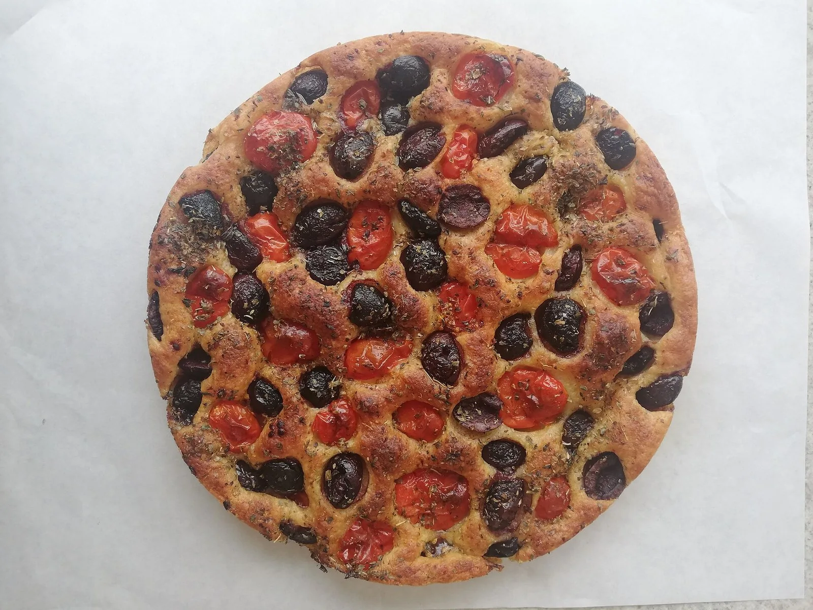Una focaccia barese con pomodorini e olive